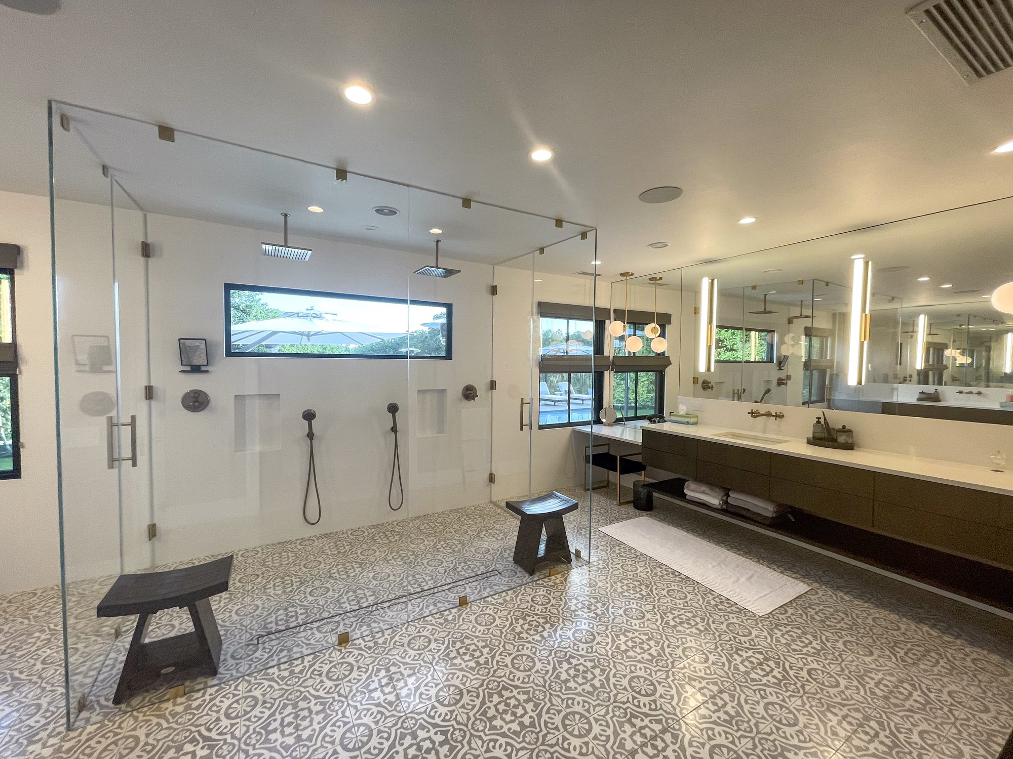 Primary bathroom with glass shower and patterned tile floor