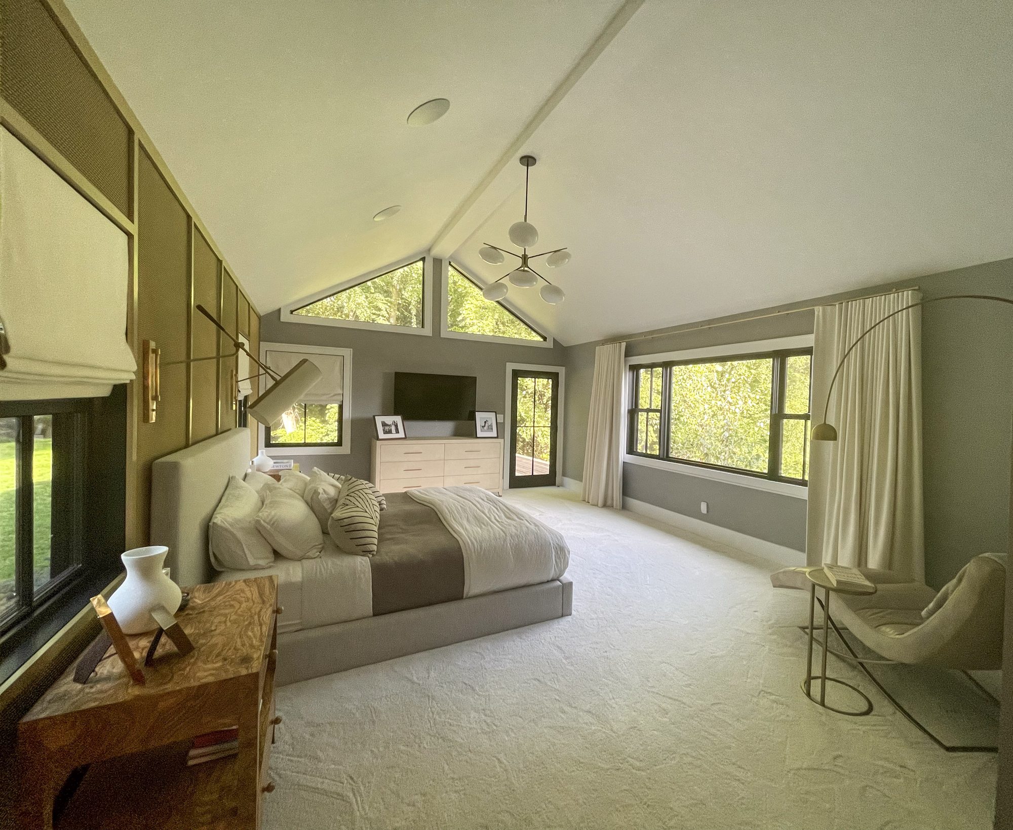 Primary bedroom with vaulted ceiling and brass accent wall