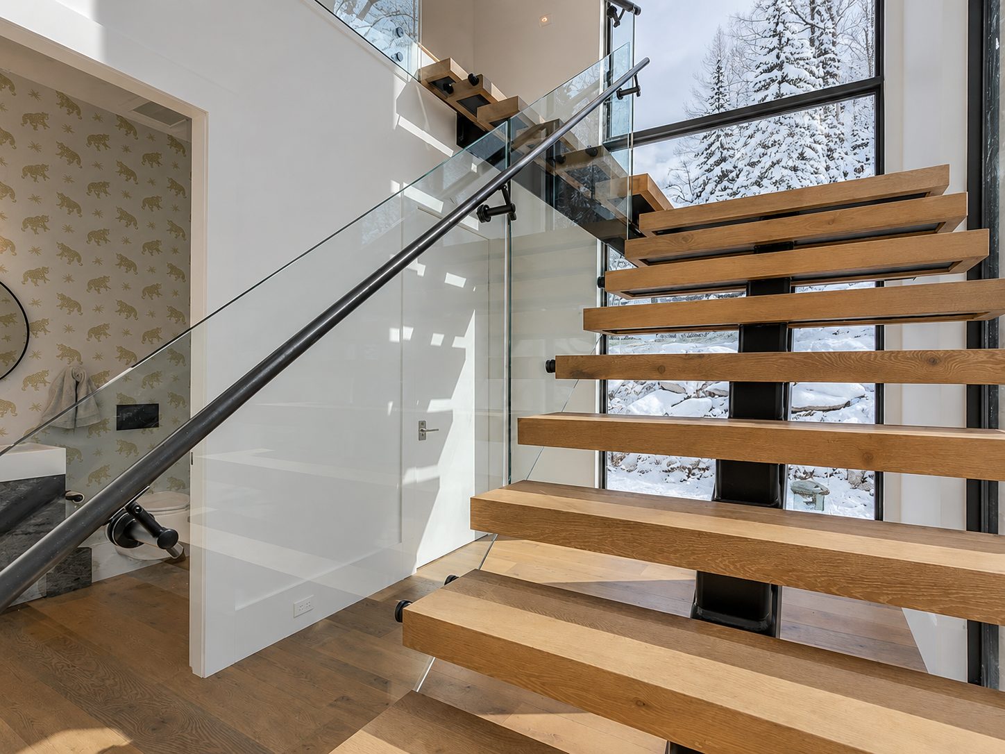 Close view of floating wood stair treads with glass railing