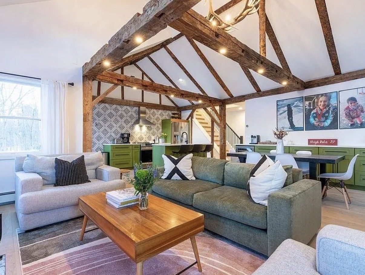 Open living and dining area with exposed barn frame