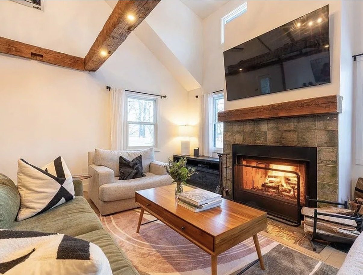 Living room with stone fireplace and exposed beams